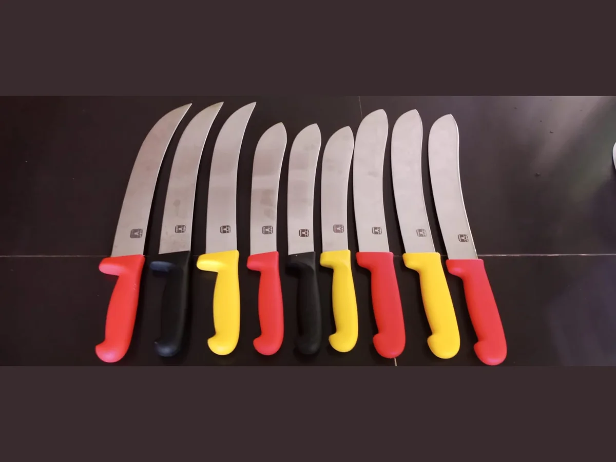 Butcher Knife Row of butcher knives with curved stainless steel blades and red, black and yellow handles