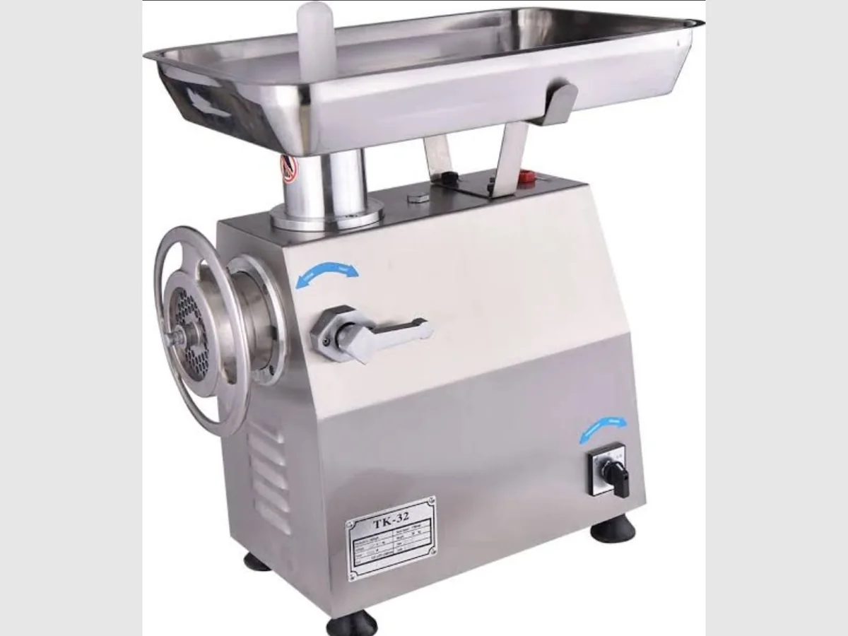 Stainless steel electric meat mincer with feed tray, hand wheel and perforated mincing plate, labelled TK-32