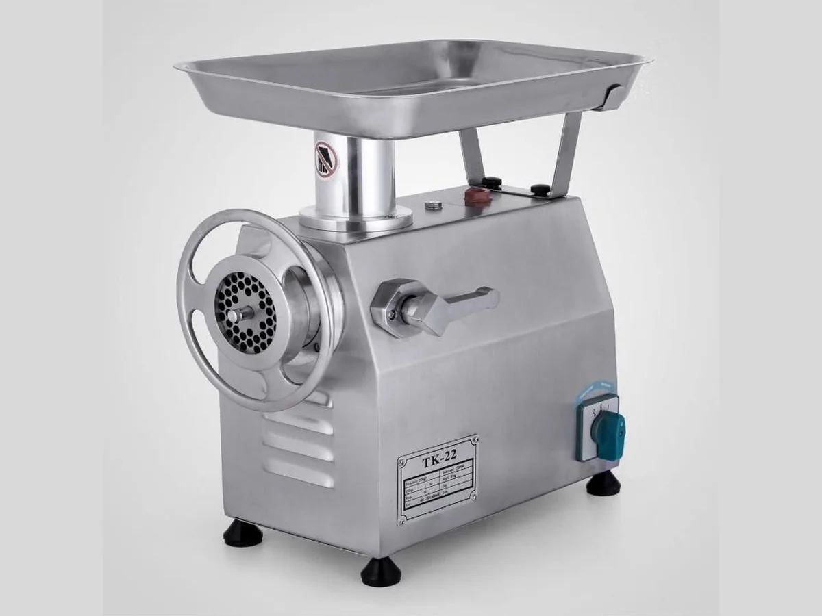 Stainless steel electric meat mincer with feed tray, hand wheel and perforated mincing plate, labelled TK-22